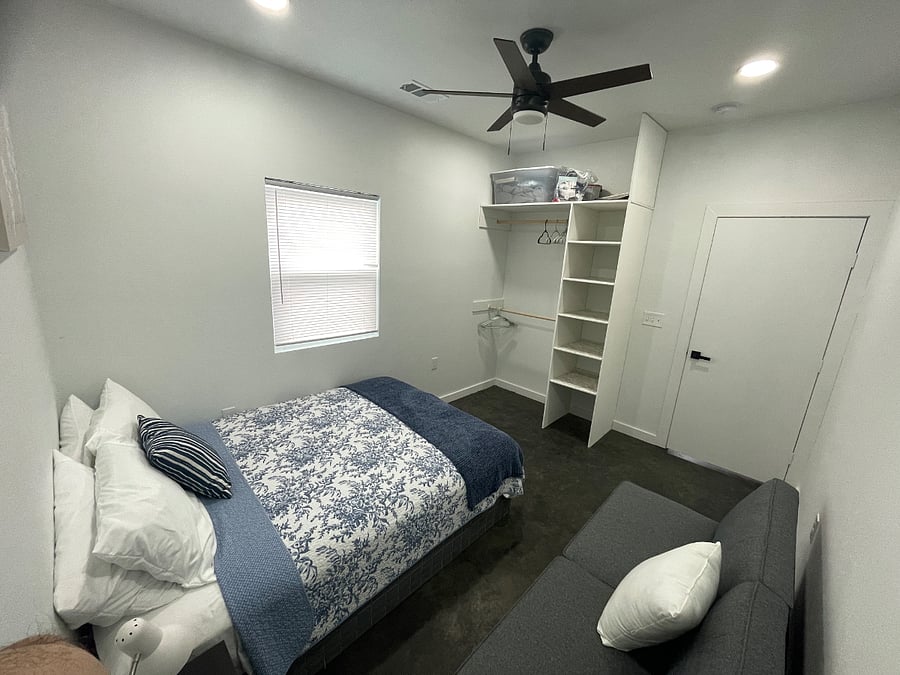 Bedroom Two is a cozy and versatile space featuring a comfortable bed, a futon for lounging or additional sleeping, and an open closet with plenty of storage. Youll find double rod hangers, multiple shelves, and a spacious top shelfperfect for organizing clothes and storing larger items during your stay.