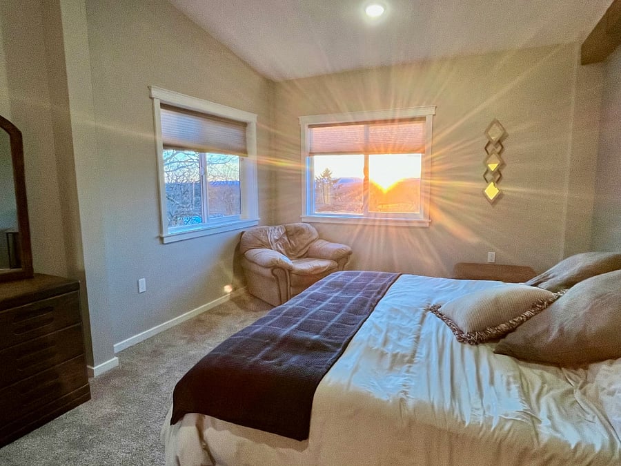 Main Bedroom, lounge chair in corner, sunset coming in thru window