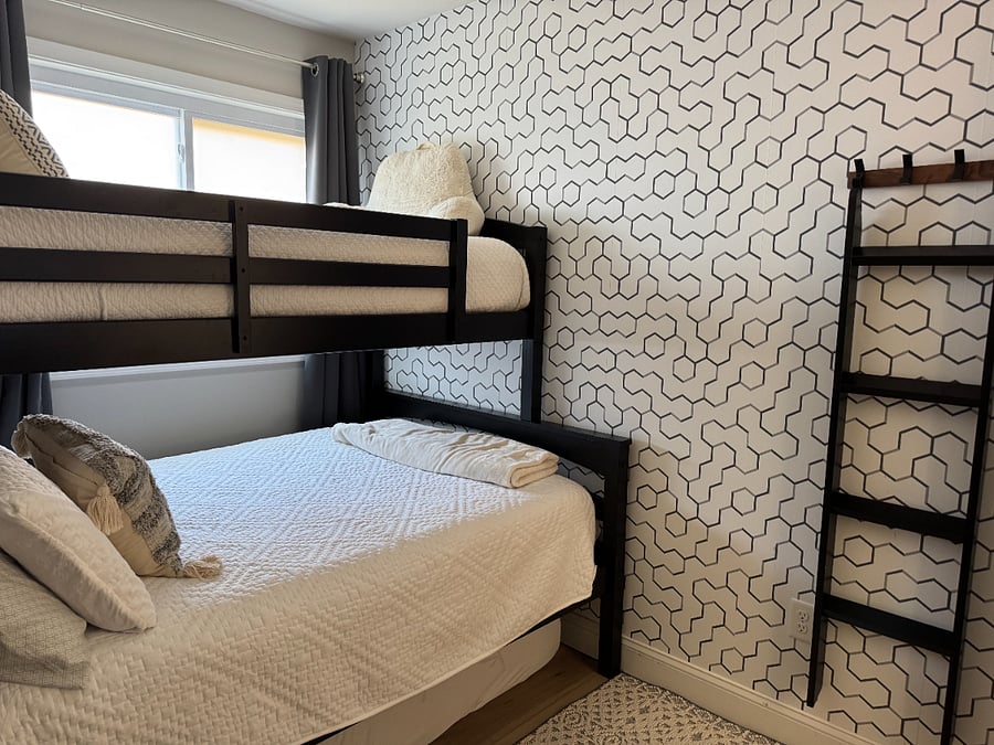 Second bedroom with twin over full bunkbed. Tall boy dresser for clothes storage.