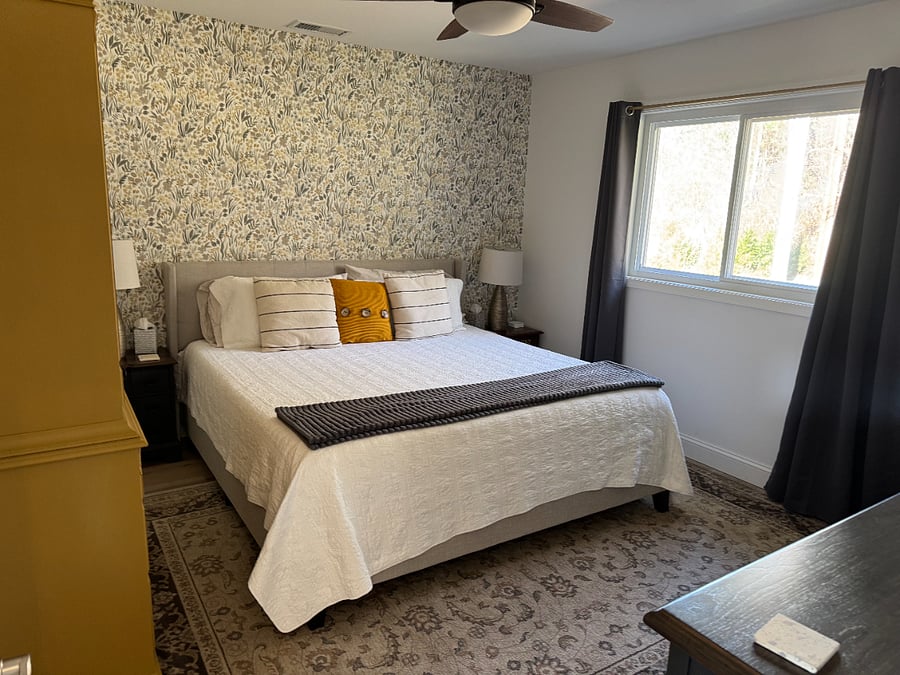 Primary bedroom with King bed. Large dresser with mirror and armoire for clothes storage.