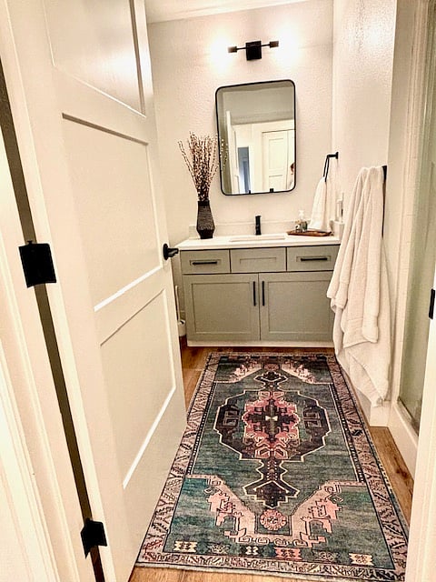 Step into a bathroom that exudes modern elegance and a welcoming charm. Sleek black faucets serve as bold, stylish focal points, complementing the fresh, crisp lines of the brand-new sink and countertops.