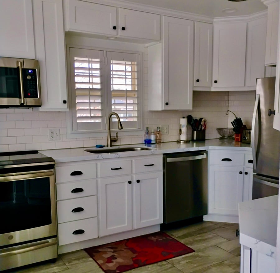 Kitchen with two ovens, stovetop, dishwasher, fridge, coffee machine, and lots of pantry storage.