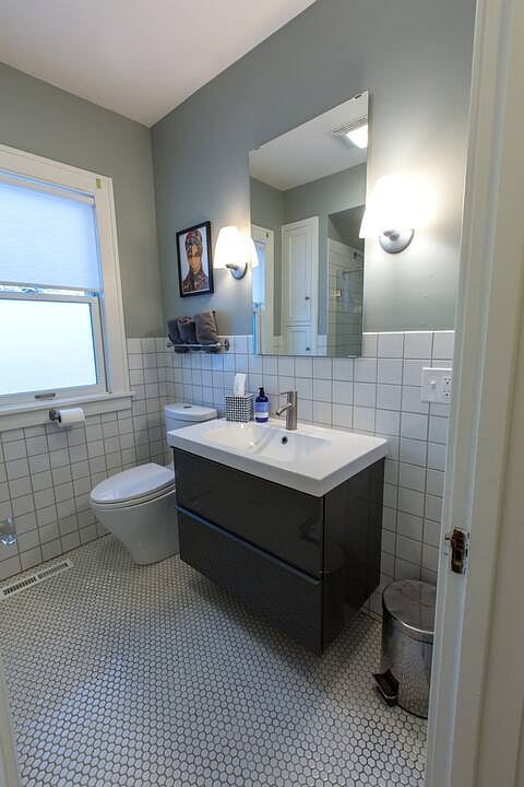 Our full bathroom is located on the first floor off the back hall.  Prince ll the 90s edition by local artist Kristi Abbott.