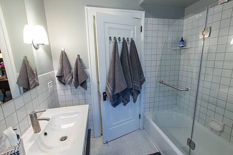 Our Full Bathroom has a glass door enclosed bathtub with shower.