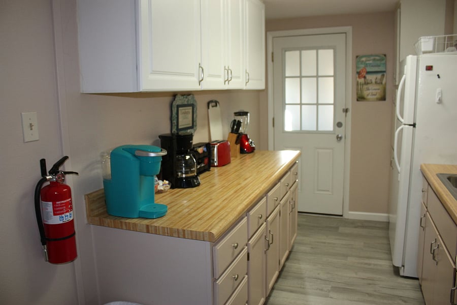 Kitchen area facing door that leads to shared laundry room
