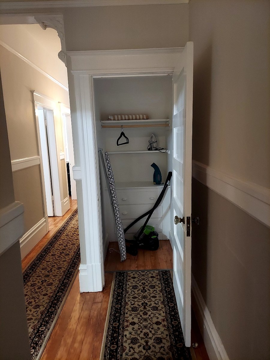 Hall closet with ironing board, iron, steamer