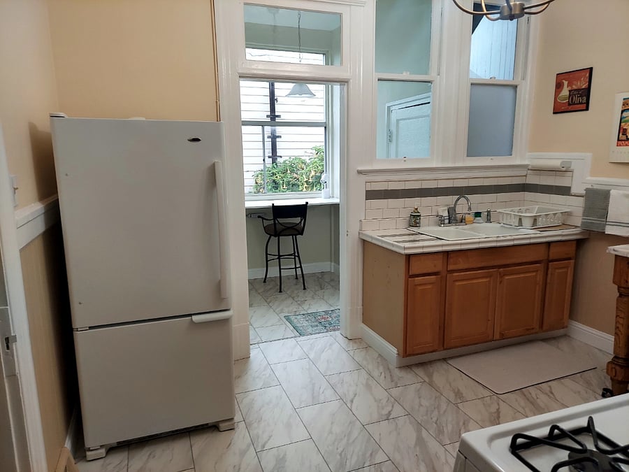 Kitchen opens onto nook with bulletin board, Swiffer, broom. Great space for work/crafting.