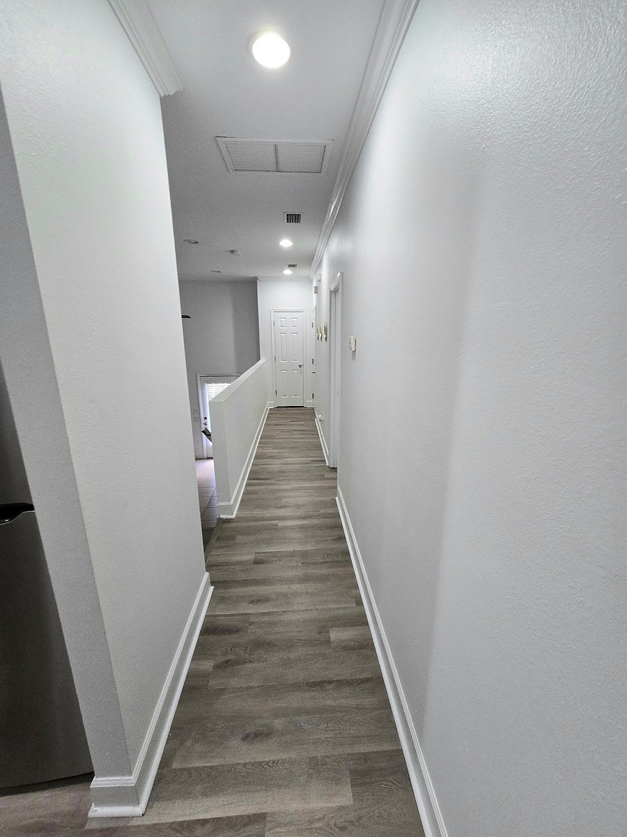 Hall that leads to downstairs den area and upper entrance