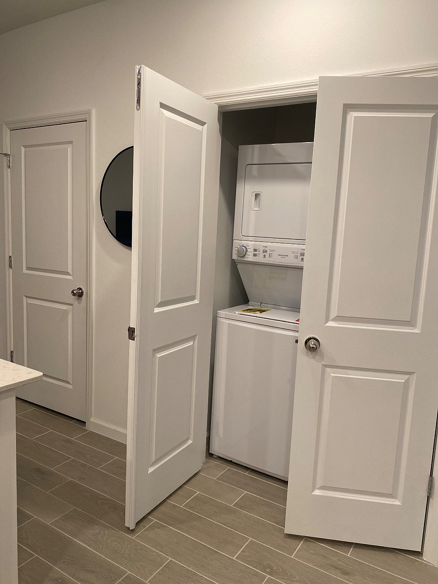 The laundry room is conveniently situated near the kitchen, making it easy to do laundry while preparing meals or enjoying a cup of coffee.