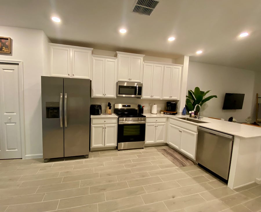 The kitchen is well-stocked with cookware and appliances, including pans, pots, utensils, a blender, a toaster, and an air fryer.