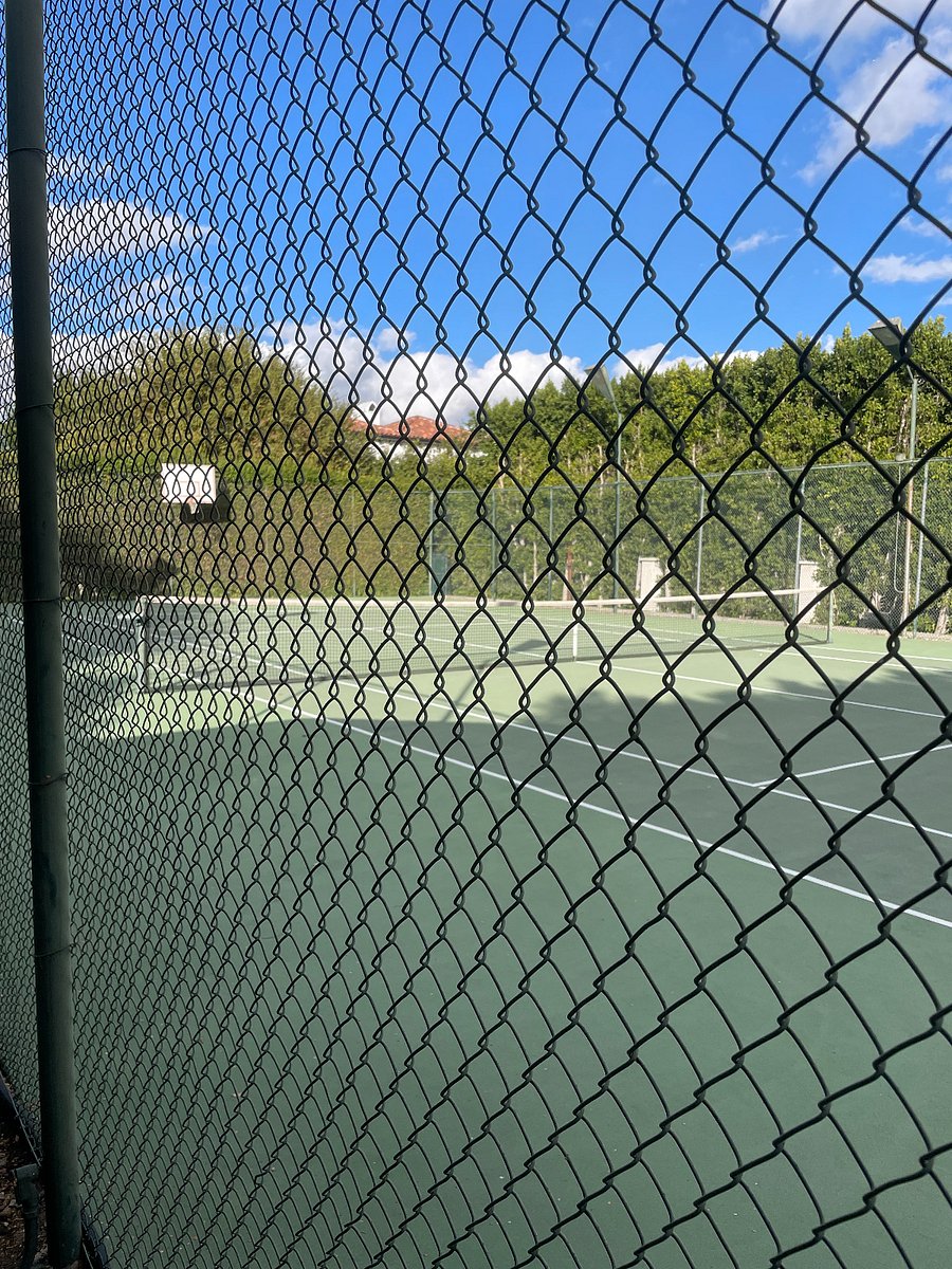 Adjacent tennis court. House includes set of pickleball paddles and ball and tennis rackets and balls.