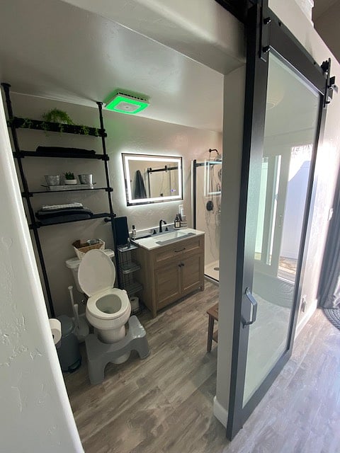 Bathroom with ADA toilet, walk in shower, bathroom fan with WI-FI built-in speaker and ambient colored lighting.