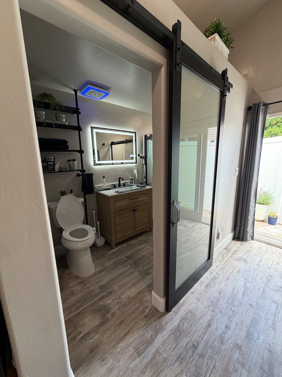 Bathroom with ADA toilet, walk in shower, bathroom fan with WI-FI built-in speaker and ambient colored lighting. 
