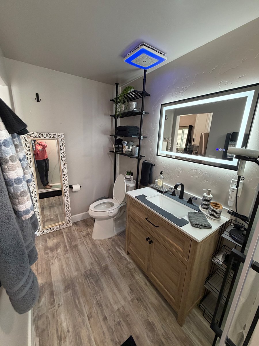 Bathroom with ADA toilet, blow-dryer with stand, walk in shower, bathroom fan with WI-FI built-in speaker and ambient colored lighting. Including full size mirror and rack for towels. 