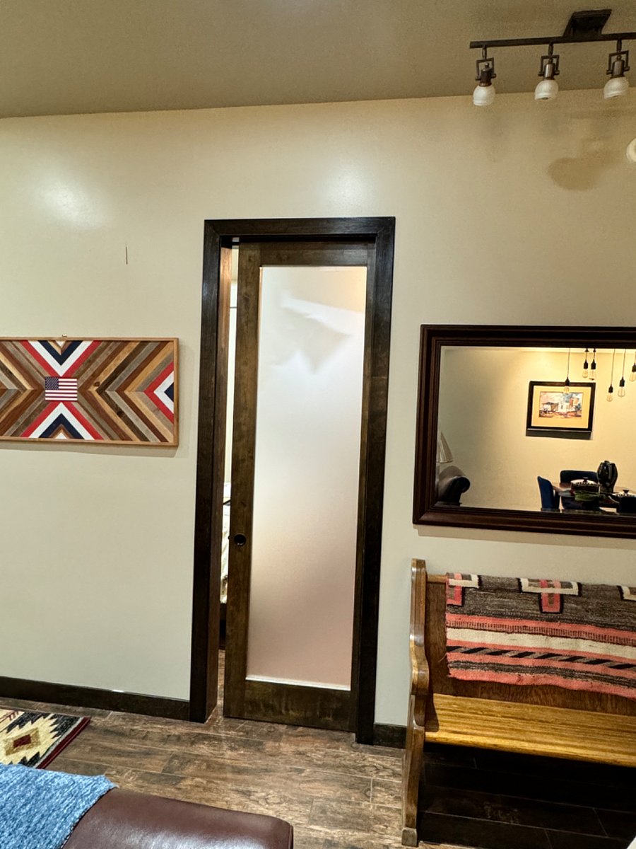 Frosted glass pocket door separating family room from primary bedroom