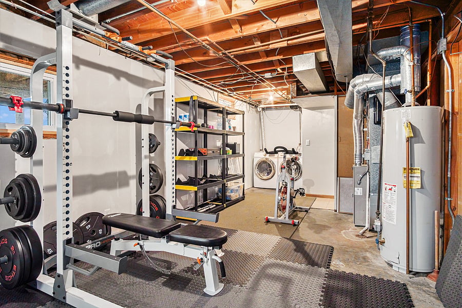 Gym includes treadmill, power rack, bike, and cable system.