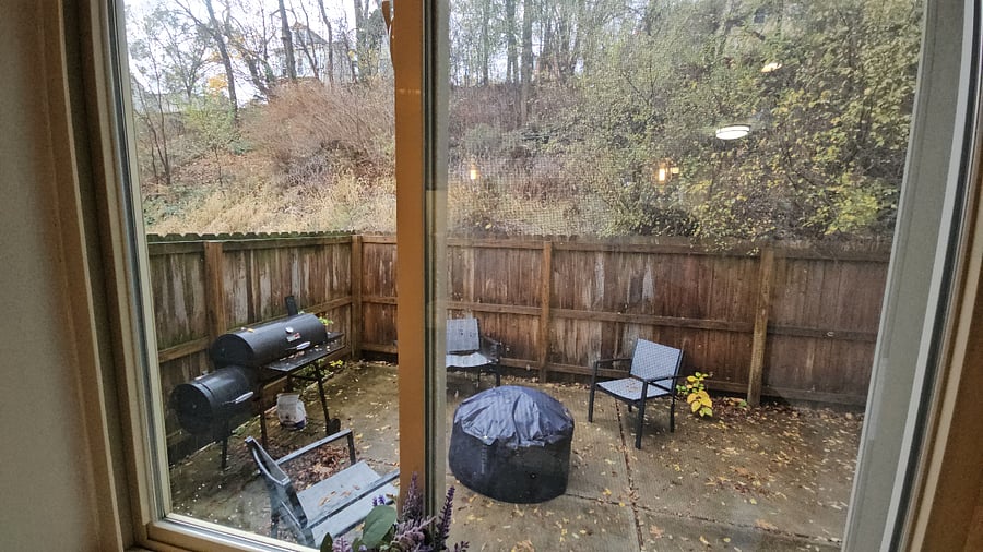 Fenced backyard with grill (charcoal and wood fire), fire pit, and outdoor sits.