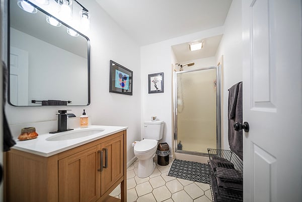 Fresh vanity and fixtures. Just outside the bathroom, there is a storage closet for additional linens.