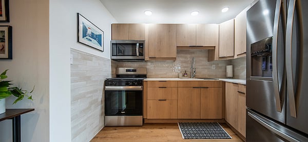 New kitchen featuring quartz countertops and stainless steel appliances. Cookware, bakeware, small appliances, and table service for four are supplied.