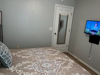 Guest bedroom 1, with mirror and hooks on door