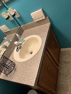 Guest bathroom mirror, sink, and counter
