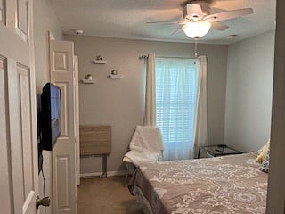 Guest bedroom 1, with smart TV, chair, and folding table