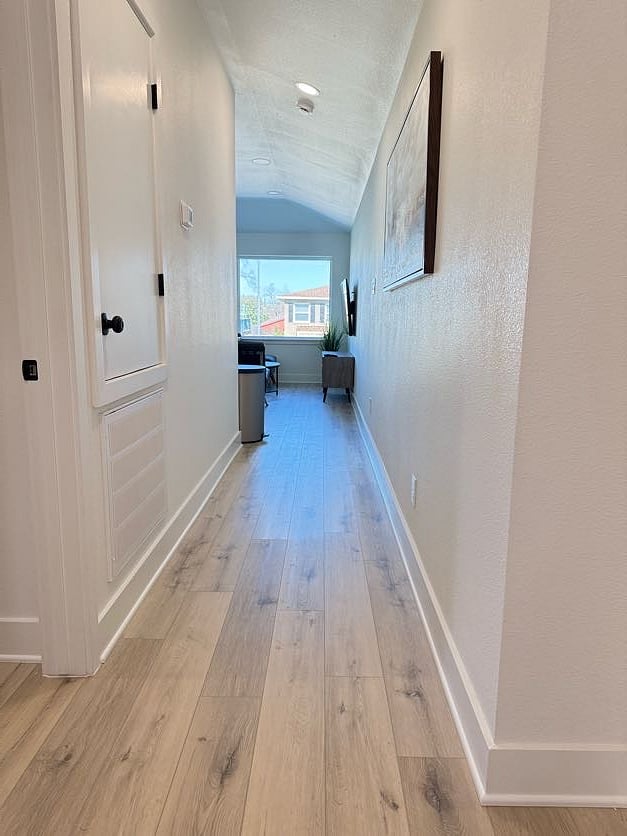 Hallway leading to living, dining, and kitchen area from Amber Room