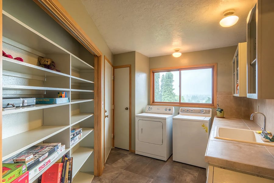 Laundry room with storage for pantry items, a utility sink, and a closet. I provide board games, cleaning supplies, a vitamix blender and an extra coffee maker.