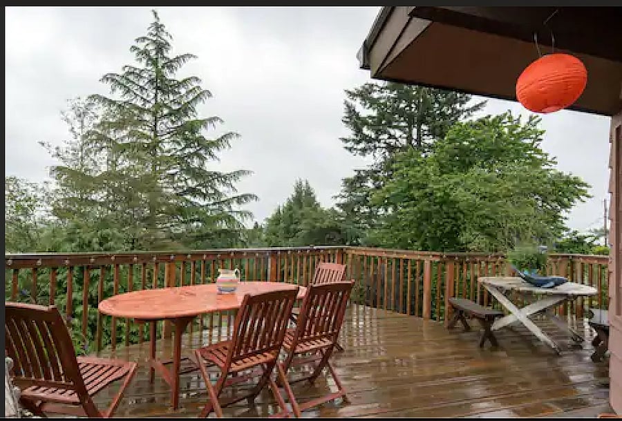 wrap around deck with table and chairs and lights for the evening.