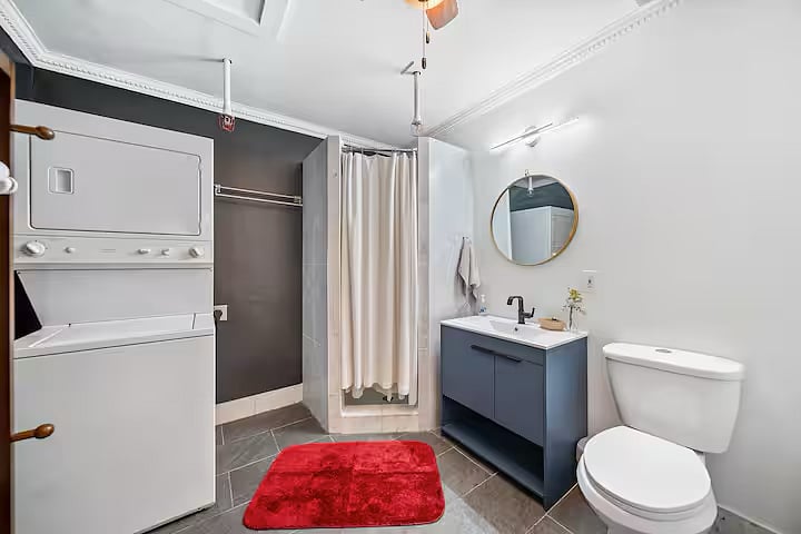Bathroom with stalled shower and laundry units