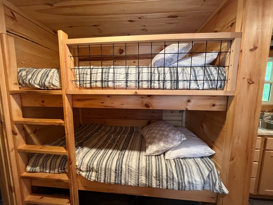 There are twin bunk beds in the hallway connecting the kitchen to the bedroom.