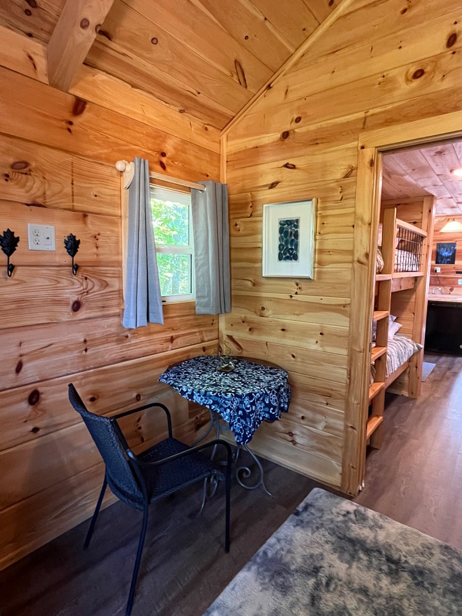 The main bedroom has a queen bed, small table, and bureau for clothing storage.