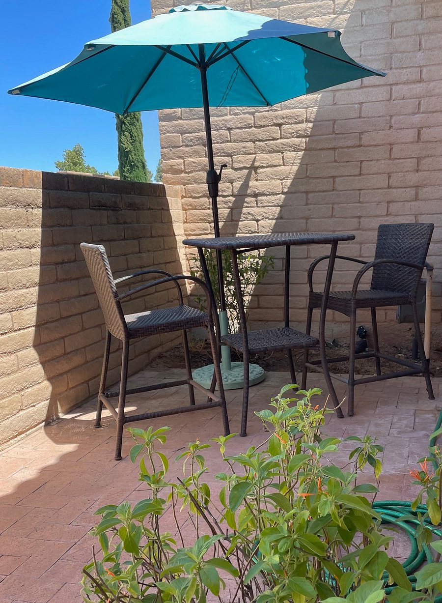 Cafe table and chairs in private courtyard.  Umbrella has solar lights for evening dining.  