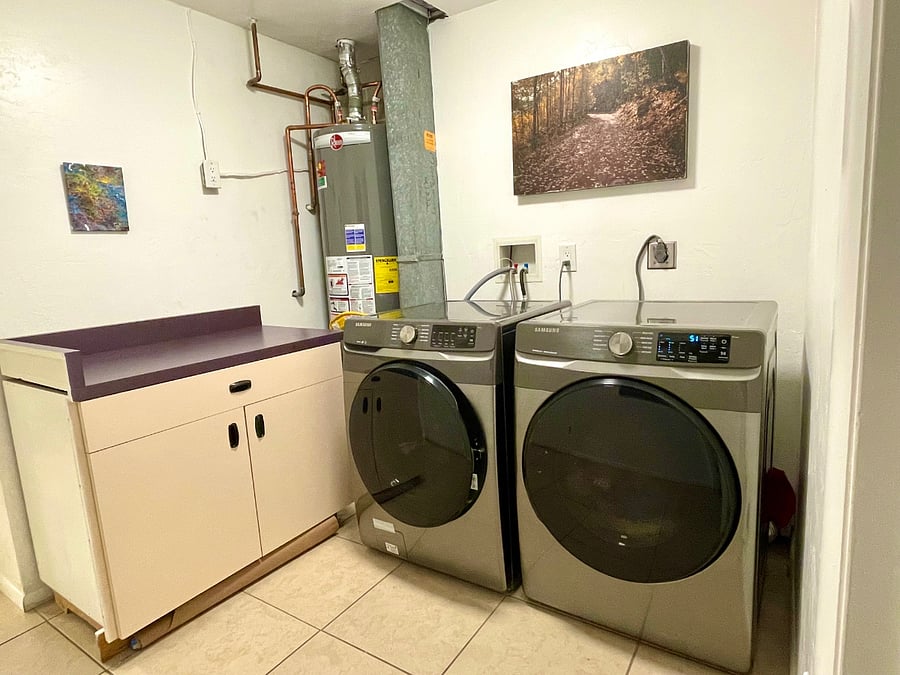 Laundry room connects garage and kitchen.  Large laundry sorting and folding area. Starter supply of laundry soap and other cleaning supplies in storage cabinet 