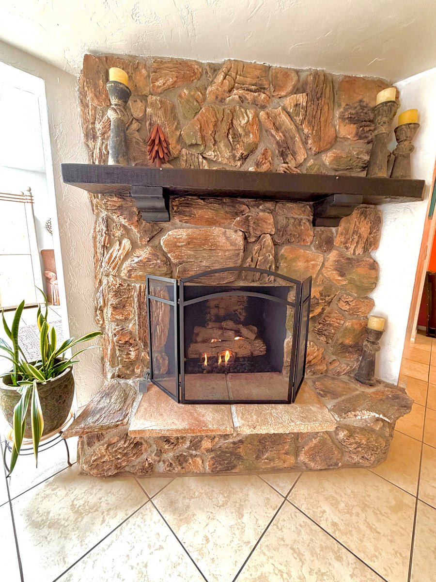 Gas log stone fireplace in living room.  