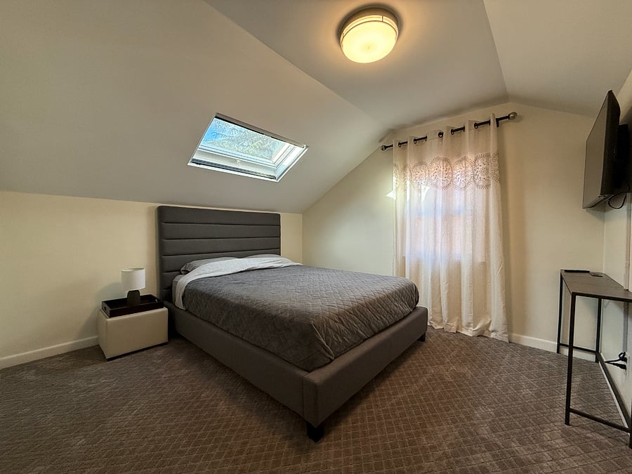 Bright and cozy bedroom with a charming skylight