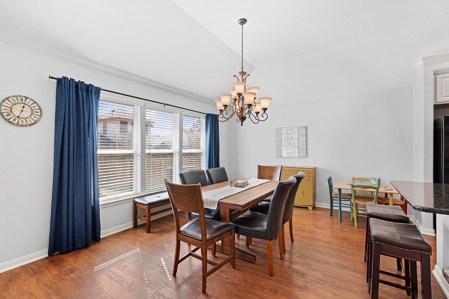 Dining area off kitchen is spacious and bright, with high ceilings and wall of windows.