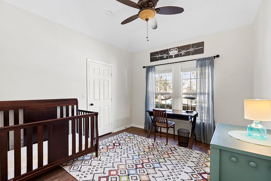 Fourth bedroom with blackout window shades is currently set up as an office. A crib, changing table, and dresser are available.