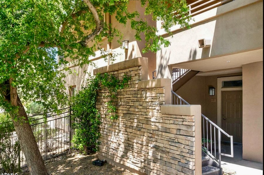 Private end entry with gas grills and small grass yard.