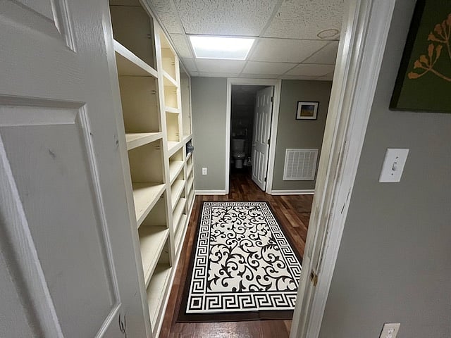 Space between bedroom, bathroom, and kitchen which features a deep closet for storage and plenty of shelving for additional storage. 