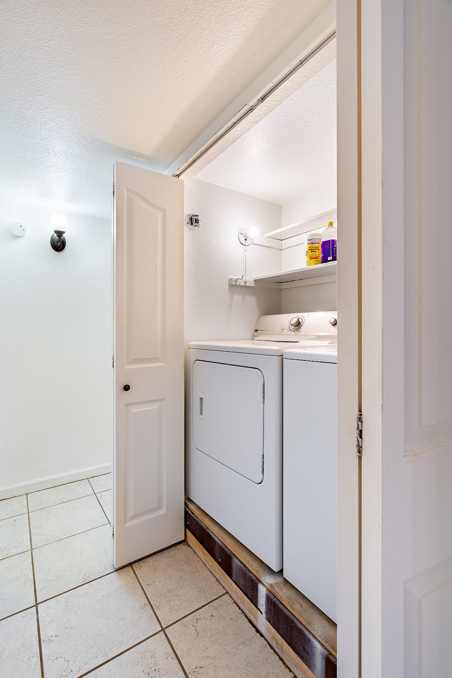 Hallway closet with cleaning supplies and Maytag washer/dryer