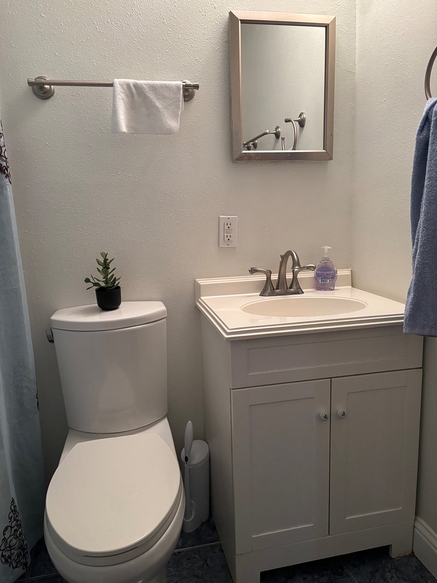 Full bathroom with extra linens, starter supplies & iron/ironing board.