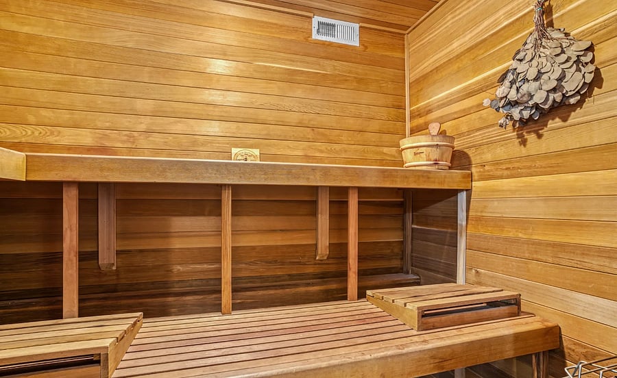 Large bathroom with double vanity, walk-in shower, separate toilet room, large soaking bath tub, and sauna. 