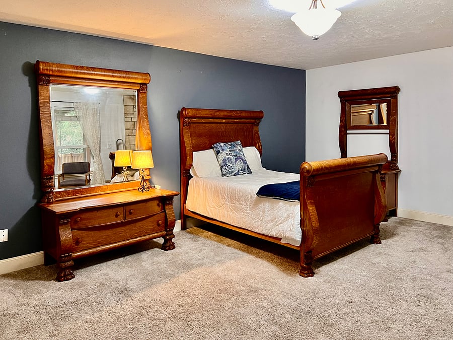 Primary bedroom includes antique oak bedroom set with full/double bed. Can swap for king bed that doesn't match if preferred.