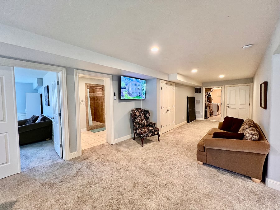 Large "main hall living area" includes wall-mounted TV, couch and chair. 