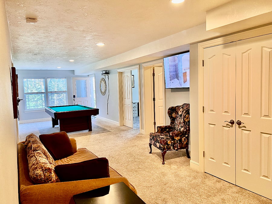 Large "main hall living area" includes wall-mounted TV, couch and chair, with a pool table for entertainment, that doubles as a ping-pong table.