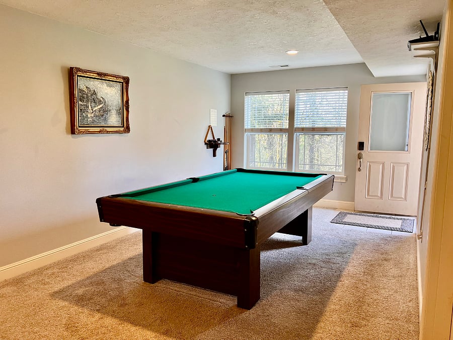 Large "main hall living area" includes wall-mounted TV, couch and chair, with a pool table for entertainment, that doubles as a ping-pong table.