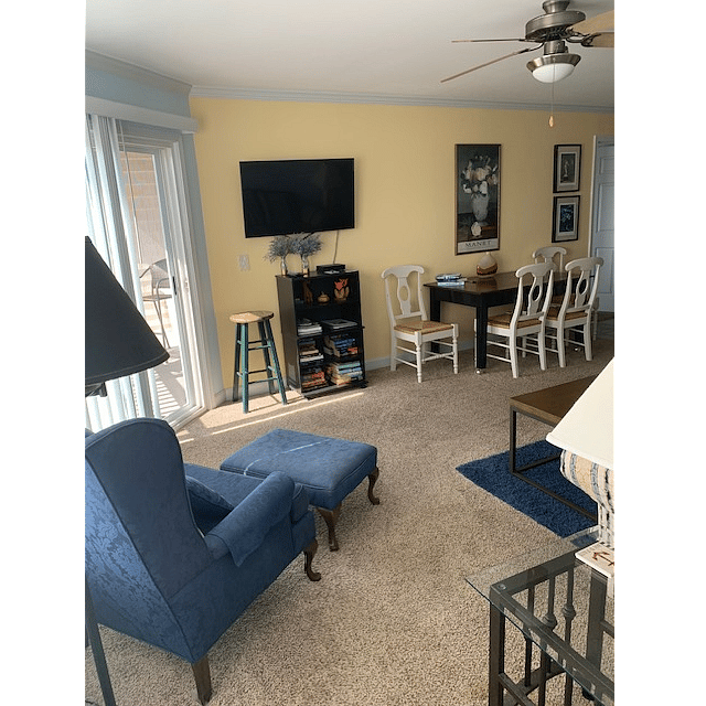 Living room, TV with cable, small bookcase w/varied selection of books, dining area ...
