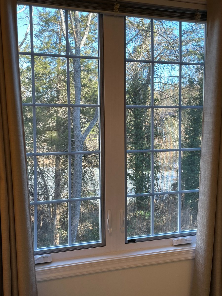 View of pond and woods behind the house.  Drapes are 100% blackout for day sleeping.