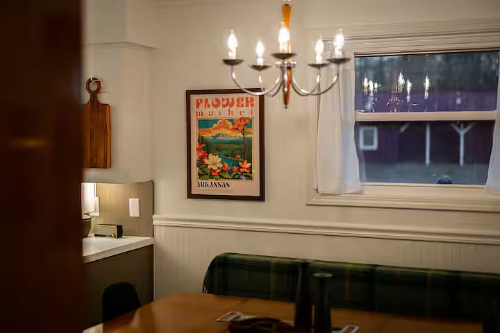The dining space is open to the kitchen allowing guests to interact while cooking or dining. Have a seat at the peninsula's stool. The dining table seats 7-8 with comfortable modern chairs or a vintage bench. The vintage chandelier is dimmable.